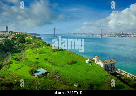 Antenne Panorama der April 25 Brücke über die Targus Fluss zwischen Lissabon und Almada mit einem gigantischen Jesus Christus Statue und die Almada Schloss Stockfoto