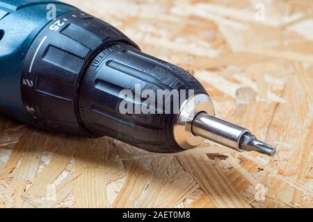 Detail der elektrischen Schraubendreher mit Torx Bit liegen auf Chip board. Unscharfer Hintergrund. Stockfoto