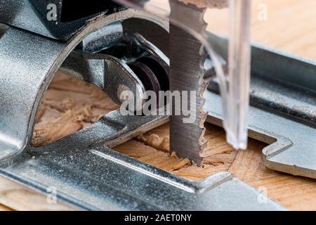 Eine elektrische Stichsäge schneiden durch Chip board. Unscharfer Hintergrund. Stockfoto