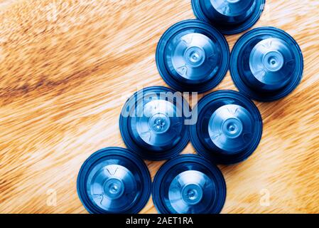 Blaue Espresso Kaffee Kapseln oder Hülsen und Kaffeebohnen auf Holz rustikale Hintergrund, Ansicht von oben Stockfoto