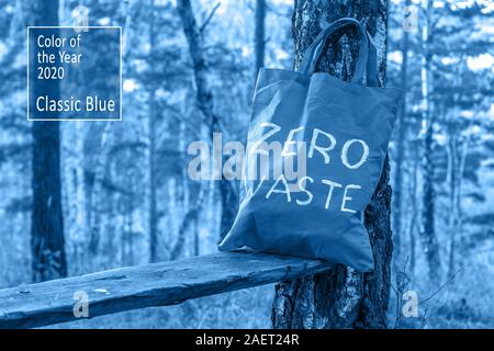 Farbe des Jahres 2020 Classic blau Pantone. Stehen in einem Wald auf einer Bank in der Nähe einer Birke, ein Textil grün Beutel mit der Aufschrift null Abfall. Stockfoto