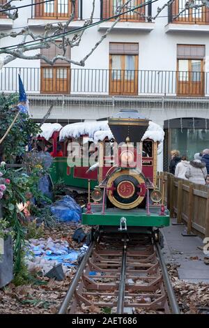 Kinder fahren eine kleine verschneite Dampfzug in Torrejón de Ardoz Weihnachtsmarkt Stockfoto