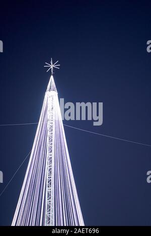 Ein riesiger vereinfachter Weihnachtsbaum, bestehend aus beleuchteten weißen Kabeln, einem Mittelpfeiler und einem darüber liegenden Stern auf der Torrejon de Ardoz Christmas Fair Stockfoto