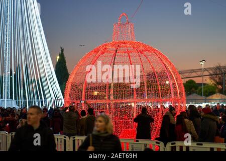 Eine grosse rote Weihnachtskugel zieht die Massen an den Weihnachtsmarkt in Torrejon de Ardoz, Madrid, Spanien Stockfoto