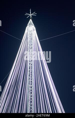 Ein riesiger vereinfachter Weihnachtsbaum, bestehend aus beleuchteten weißen Kabeln, einem Mittelpfeiler und einem darüber liegenden Stern auf der Torrejon de Ardoz Christmas Fair Stockfoto