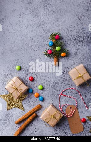 Weihnachten Hintergrund mit mini Weihnachtsbaum, Geschenkboxen, festliche Dekoration, Tannenbaum, Bonbons, Zimtstangen Stockfoto