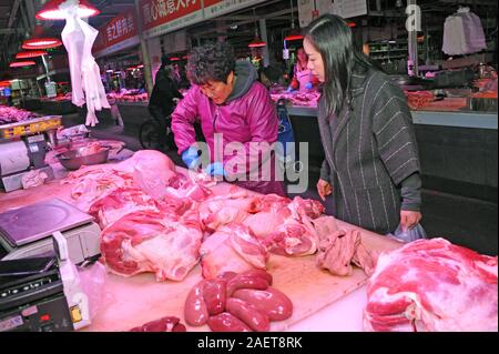 Kunden kaufen Schweinefleisch um einen Stand auf einem lokalen Markt in Tianjin, China, 16. November 2019. Der Preis für Schweinefleisch weiter gehen als die Regierung o Stockfoto