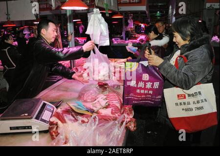 Kunden kaufen Schweinefleisch um einen Stand auf einem lokalen Markt in Tianjin, China, 16. November 2019. Der Preis für Schweinefleisch weiter gehen als die Regierung o Stockfoto