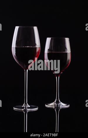 Zwei Gläser mit Rotwein auf einem schwarzen Hintergrund. Wein auf der dunklen Stockfoto