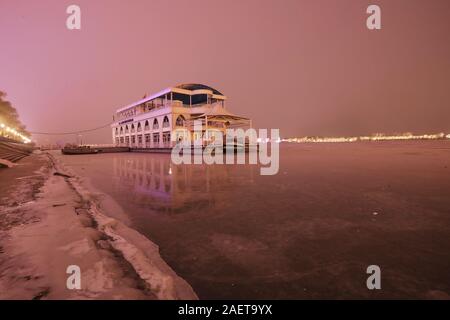 Ein Fischerboot Häfen am Songhua-fluss, das ist der größte Nebenfluss des Flusses Heilongjiang und friert wegen der drastischen Temperaturabfall, Witz Stockfoto