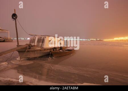 Ein Fischerboot Häfen am Songhua-fluss, das ist der größte Nebenfluss des Flusses Heilongjiang und friert wegen der drastischen Temperaturabfall, Witz Stockfoto