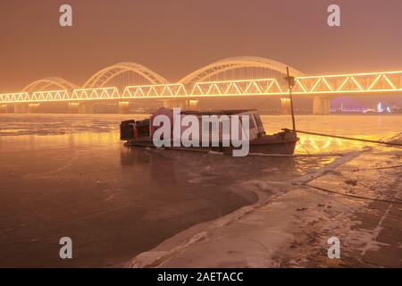 Ein Fischerboot Häfen am Songhua-fluss, das ist der größte Nebenfluss des Flusses Heilongjiang und friert wegen der drastischen Temperaturabfall, Witz Stockfoto