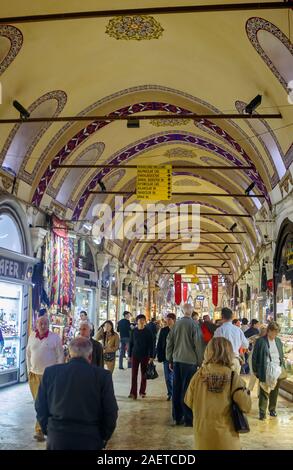 Käufer und Touristen Store durchsuchen Windows in einem überdachten Fußgängerzone Arcade an der berühmten Grand Bazaar, Istanbul, Türkei Stockfoto