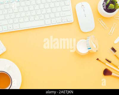 Um Naturkosmetik online. Frische grüne Blätter, Wattepads, body Duschgel handgemachte Seife, Gesichtscreme und eine Tastatur isoliert auf einem gelben Stockfoto