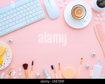 Tastatur, Maus, eine Tasse Tee mit zitronenscheibe und Make-up-Werkzeuge und kosmetische Produkte rund um es auf einem rosa Hintergrund isoliert. Flach, Ansicht von oben kopieren Stockfoto