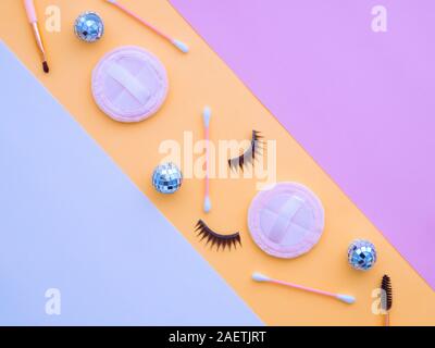 Hellblau weiß rosa gelb Pastell Papier geometrische flach Hintergrund mit Make-up-Tools, Weihnachtskugeln, Puderquasten, Wattestäbchen, falsche Ey Stockfoto