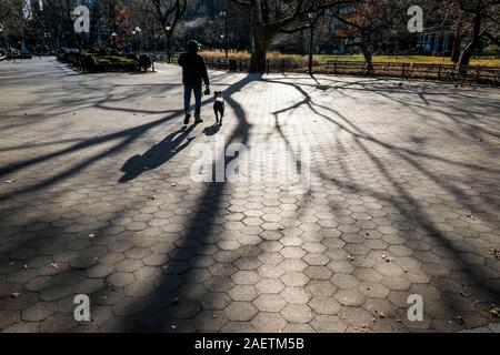 Fußgänger Spaziergang durch Washington Square, NEW YORK CITY, im Winter Licht. Stockfoto