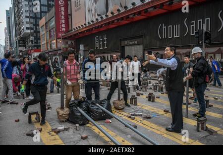 In Mong Kok, Tin Shui Wai und Sai Wan Ho, drei Bereiche, die die Hauptlast der rampages Randalierer in den letzten Tagen trug, Bewohner hoben Steine und Müll le Stockfoto