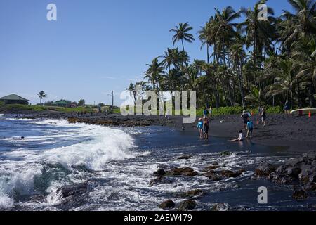 Besucher am Punalu'U Black Sand Beach, einem Strand zwischen Pāhala und Nāʻālehu auf der Big Island, Hawaii, am Donnerstag, 28. November 2019. Stockfoto