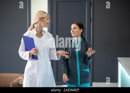 Leitender Arzt in eine weiße Robe mit jungen intern Stockfoto