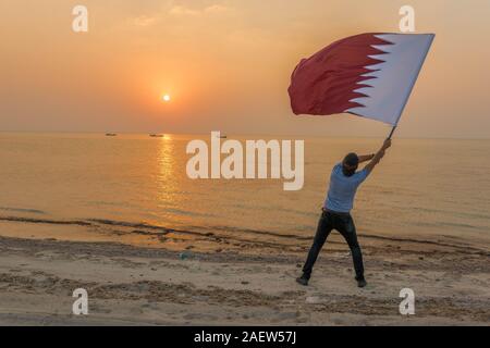 Ein Mann winkte Katar Flagge Stockfoto