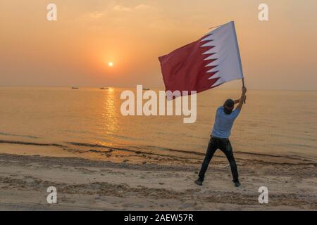 Ein Mann winkte Katar Flagge Stockfoto