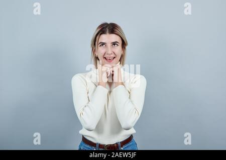 Hübsche Junge kaukasier Dame, mit der Faust auf das Kinn sieht lustig Stockfoto