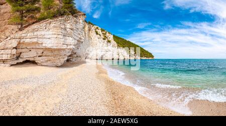Wunderschönen Kiesstrand von hohen massiven weißen Kalkstein Felsen von Adria Wellen und Wind erodiert umgeben. Grüne Aleppo-kiefern wächst an. Stockfoto