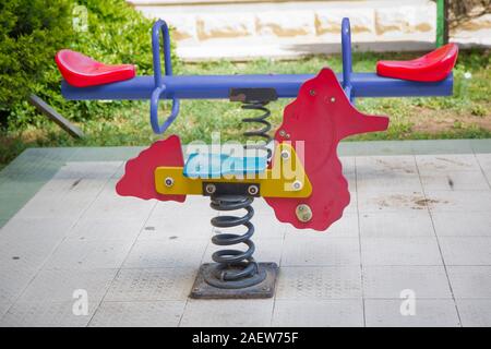 Auf Kind Spielplatz im Park Wippe. childs Ausritt mit dem Pferd in den Spielplatz. Schwingen auf einer metallspirale. Feder Pferd auf dem Spielplatz. Stockfoto