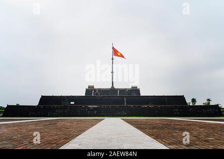 Flagge von Vietnam über einen Turm der Zitadelle auf blauen Himmel Hintergrund. Innerhalb der Zitadelle ist die Verbotene Stadt. Hue, Vietnam. Stockfoto