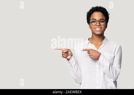 Lächelnd schwarze junge Frau neben Hinweisen auf leere Kopie Raum. Stockfoto