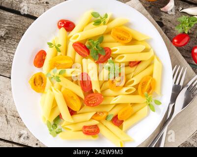 Nudeln mit Tomaten mit Basilikum auf dem alten rustikalen grau Holz- Hintergrund eingerichtet, kalorienarme Diät, Ansicht von oben, close-up Stockfoto