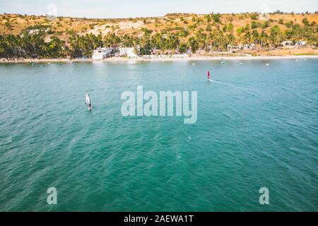 Mui Ne, Vietnam. Mann spielen Surfen Sport im Meer unter weiten blauen Himmel. top Aussicht, Luftaufnahme, Stockfoto