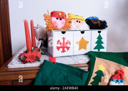 Weihnachtsbaumschmuck close-up. Rote Kerzen mit Blumen. Candy Felder mit den Drei Weisen und Weihnachtssocken für Geschenke. Stockfoto