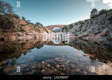 Alte Steinbrücke von Ponte Vecchiu Genueser Brücke über den kristallklaren Fango Fluss in Korsika Stockfoto