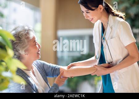 Junger Arzt untersucht ältere Frau Stockfoto