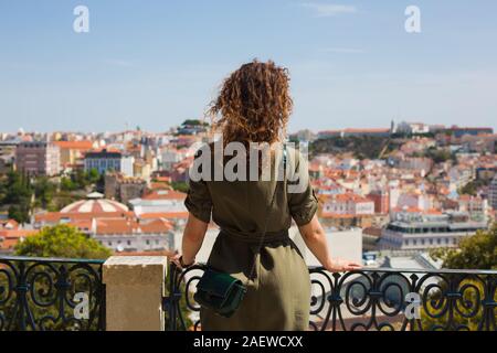 Eine junge Frau steht auf der Aussichtsplattform und Blick auf die Dächer von Lissabon. Portugal Stockfoto