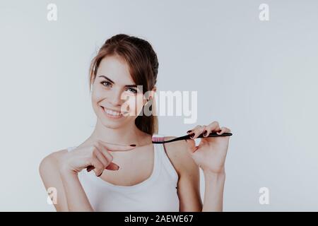 Mädchen zeigt den Finger auf die Zahnbürste Lächeln Zähne Stockfoto