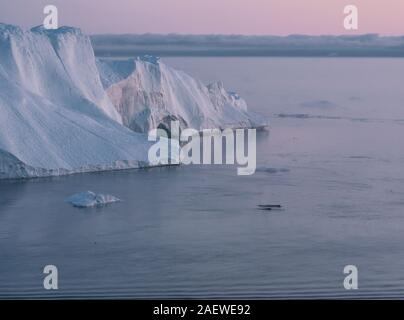 3 Buckelwal Tauchen in der Nähe von Ilulissat unter Eisberge während Pink midnight sun. Sonnenaufgang und Sonnenuntergang. Die Quelle wird von der Jakobshavn Gletscher. Die Stockfoto