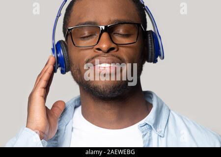 Lächelnden jungen afrikanischen amerikanischen Mann genießen Lieblingstitel. Stockfoto