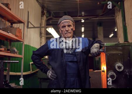 Portrait von reife Arbeitnehmer in Arbeit tragen an der Kamera, während in der Anlage stehen Stockfoto