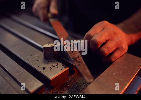 Nahaufnahme der männlichen Arbeitnehmer arbeiten mit Datei- und Metall Detail in der Factory Stockfoto