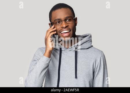 Junge schwarze Kerl in Brillen plaudern auf Handy aufgeregt. Stockfoto