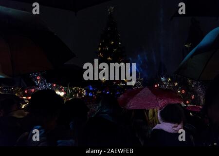 Athen, Griechenland. 10 Jan, 2020. Die Menschen warten auf die Beleuchtung der Weihnachtsbaum mit Sonnenschirmen während der Veranstaltung. Die Beleuchtung der Athen Weihnachtsbaum ist ein jährliches Fest, das jedes Jahr stattfindet in der zentralen Syntagma-Platz in der Nähe des griechischen Parlaments. Es ist eine Feier über Weihnachten mit live Musik und anderen Happenings. Credit: Nikos Pekiaridis/SOPA Images/ZUMA Draht/Alamy leben Nachrichten Stockfoto