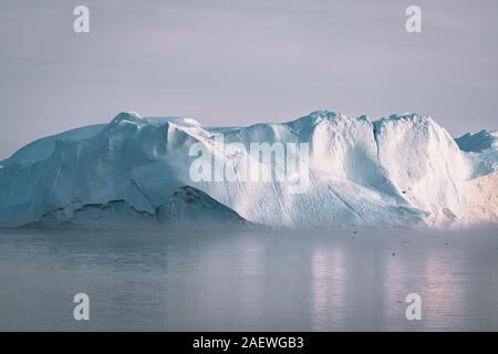 Eisberg bei Sonnenuntergang. Natur und Landschaft Grönlands. Die diskobucht. Westgrönland. Sommer Mitternachtssonne und Eisberge. Big Blue Ice im Eisfjord. Betroffen Stockfoto