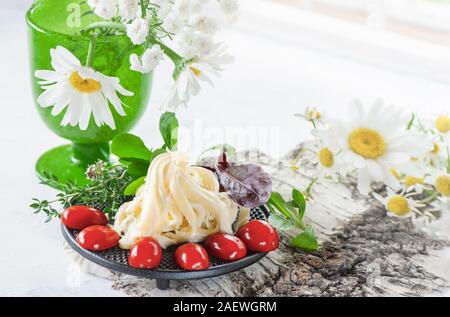 Traditionelle weiße weiche faserige Cecil Käse liegt auf einer Platte. Der Käse wird mit reifen Tomaten und stachelbeeren eingerichtet. Kopieren Sie Platz. Stockfoto
