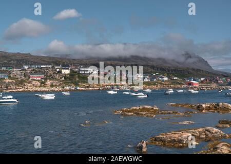 Blick über die bunten Häuser der Diskoinsel Grönland, Arktis Stadt Qeqertarsuaq. In der Disko Bucht. Blauer Himmel und sonnigen Tag. Tabelle Berge Stockfoto