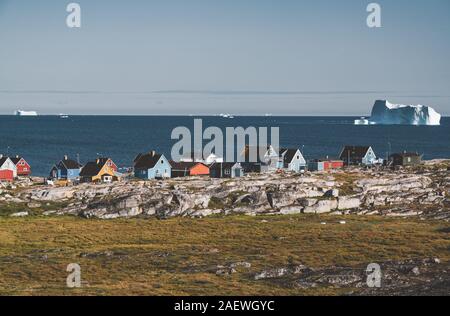 Blick über die bunten Häuser der Diskoinsel Grönland, Arktis Stadt Qeqertarsuaq. In der Disko Bucht. Blauer Himmel und sonnigen Tag. Tabelle Berge Stockfoto