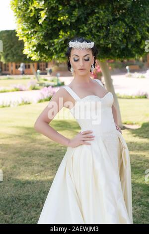 Verträumt Braut. Tipps und Tricks von Hochzeit im Ausland Experten. Sachen betrachten, Hochzeit im Ausland. Braut adorable White Wedding Dress sonnigen Tag Naturpark Hintergrund. Hochzeit im Freien. Stockfoto