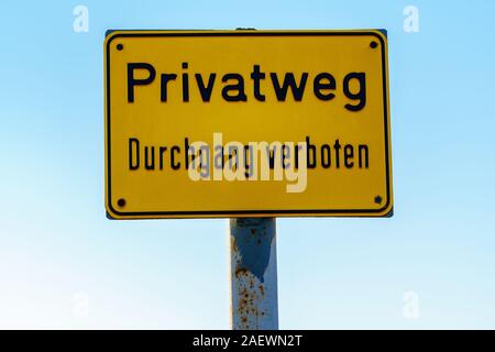 Gelbes Schild mit deutschem Text "Private Straße nicht betreten" vor der klaren blauen Himmel an einem sonnigen Tag - closeup, Querformat Stockfoto